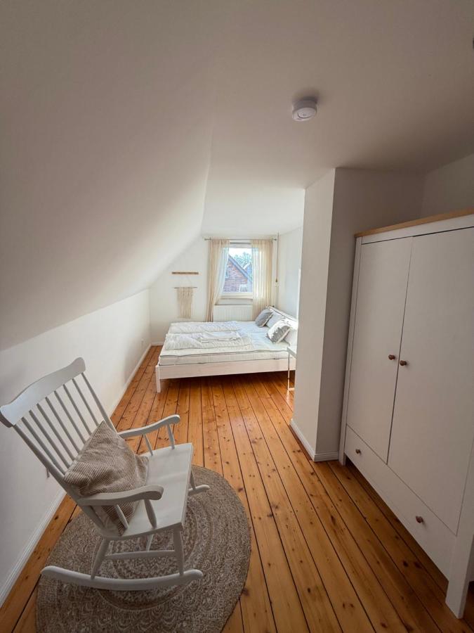 Helles Schlafzimmer mit Holzdielen und Doppelbett